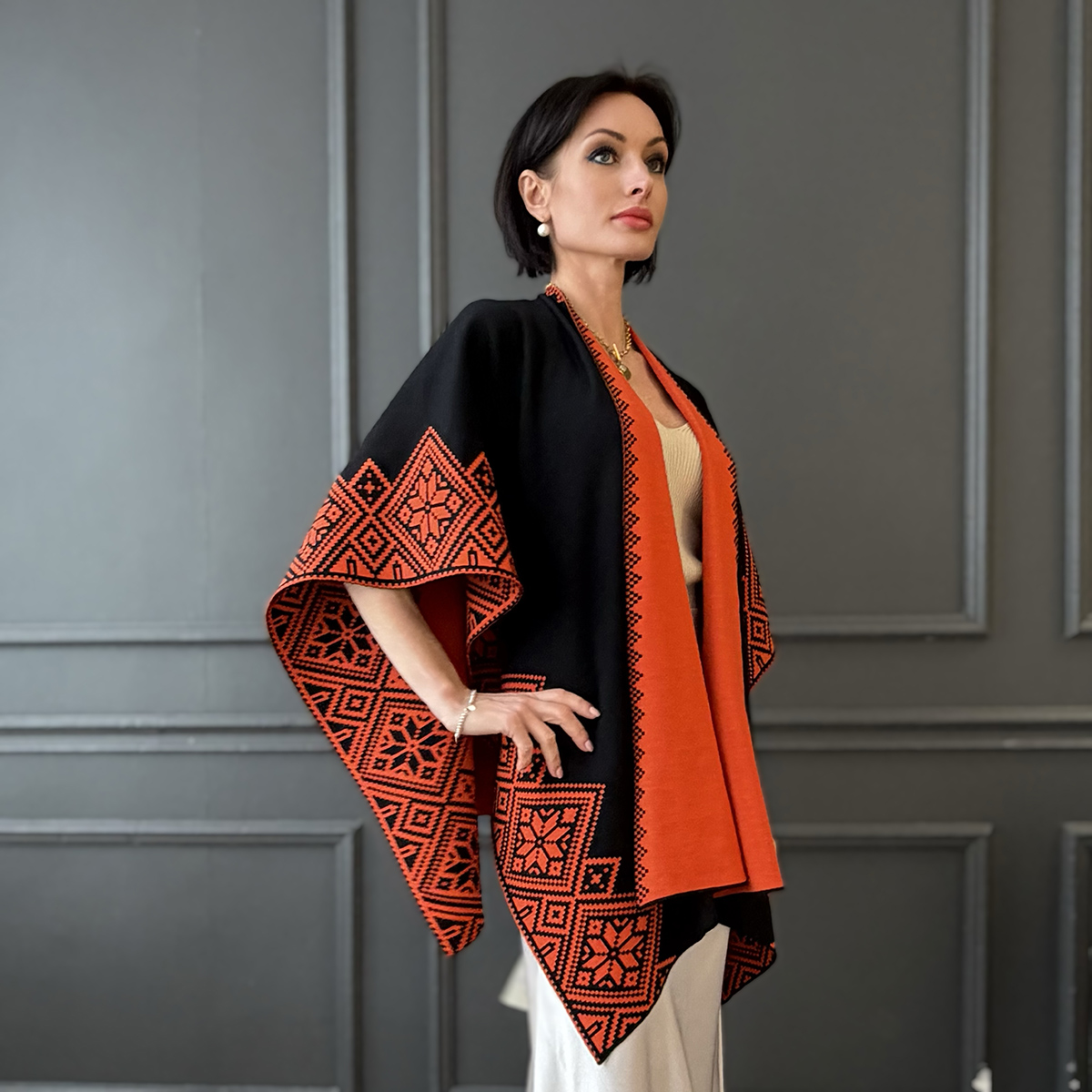 Пончо Nordstar из чистой шерсти черного цвета с оранжевым